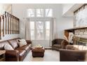 Comfortable living room with stone fireplace, large windows, and plush seating at 7883 S Windermere Cir, Littleton, CO 80120