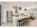 Open kitchen boasts a stainless fridge, waterfall island with seating, and adjacent dining space at 3649 W 21St Ave, Denver, CO 80211