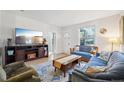 Cozy living room featuring a large TV, hardwood floors, and comfortable blue sofas at 422 Atwood St, Longmont, CO 80501