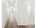 Bright hallway with wood floors and doors, leading to various rooms within the home at 9069 Pitkin St, Commerce City, CO 80022