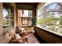 Relaxing covered porch with brick accents, wooden chairs, and a view of the neighborhood at 1267 Clayton St, Denver, CO 80206