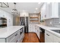 Gorgeous renovated kitchen featuring stainless appliances, designer tile backsplash, and bright countertops at 6330 E Vassar Ave, Denver, CO 80222