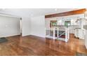 Bright living room with gleaming hardwood floors, white walls, and a view into the updated kitchen at 6330 E Vassar Ave, Denver, CO 80222