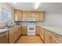 Kitchen with light wood cabinets, stainless steel appliances, and hardwood floors at 3006 W 107Th Pl # D, Westminster, CO 80031