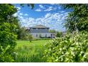 Back exterior view of a two-story home framed by lush green trees and greenery at 1106 Oak Cir, Lakewood, CO 80215