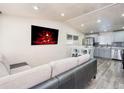 Cozy open-concept living room featuring updated flooring, a fireplace, and stainless-steel appliances at 6500 E 88Th Ave # 258, Henderson, CO 80640