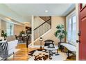 Bright and airy living room with hardwood floors, a staircase, and large windows providing ample natural light at 3047 Osceola St, Denver, CO 80212