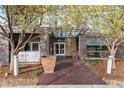 Welcoming building entrance with brick facade, glass awning, and landscaped surroundings at 2958 Syracuse St # 306, Denver, CO 80238