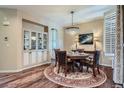 Elegant dining room with a crystal chandelier, hardwood floors, and decorative wall art at 3181 Firenze Pl, Highlands Ranch, CO 80126
