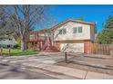 Traditional exterior featuring a two-car garage and a charming brick facade at 7065 S Willow St, Centennial, CO 80112
