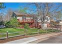 Charming two-story home with a wooden fence, a well-maintained lawn, and a deck at 7065 S Willow St, Centennial, CO 80112