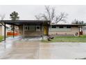 Exterior home view showing a carport, brick facade, updated windows, and modern minimalist landscaping at 6530 W 26Th Ave, Edgewater, CO 80214
