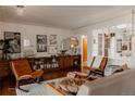 Bright living room with eclectic furnishings, hardwood floors, gallery wall, and decorative shelving unit at 6530 W 26Th Ave, Edgewater, CO 80214