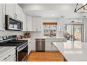 Bright kitchen featuring stainless appliances, white cabinets and herringbone backsplash at 10123 Zeno St, Commerce City, CO 80022