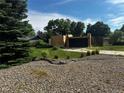Charming home with modern architectural elements, a well-manicured lawn, rock driveway, and mature trees at 6838 Harvest Rd, Boulder, CO 80301