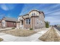 Charming two-story home with stone accents and well-manicured front lawn, located in a desirable neighborhood at 14667 Crouch Pl, Parker, CO 80134