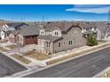 A two-story home featuring neutral siding, stone accents, a well-manicured lawn, and neighborhood views at 14667 Crouch Pl, Parker, CO 80134