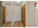 Entryway with a mirrored wall and wooden closet doors, featuring modern wood flooring at 13606 E Bates Ave # 304, Aurora, CO 80014