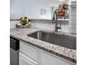 Close up on stainless steel kitchen sink with granite countertops and white cabinets at 2281 Vaughn # 104A, Aurora, CO 80014