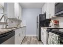 Updated kitchen with white cabinets, granite countertops, stainless steel appliances, and tile backsplash at 2281 Vaughn # 104A, Aurora, CO 80014