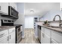 Modern kitchen featuring stainless steel appliances, white cabinetry, and tile flooring at 2281 Vaughn # 104A, Aurora, CO 80014