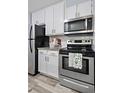Updated kitchen with stainless steel appliances, white cabinets, and granite countertops at 2281 Vaughn # 104A, Aurora, CO 80014