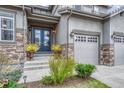 Elegant front entry with double doors, stone accents, and manicured landscaping at 2618 Bellavista St, Castle Rock, CO 80109