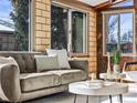 Bright sunroom features exposed brick walls, abundant natural light, and a comfortable sofa at 2348 W Ford Pl, Denver, CO 80223