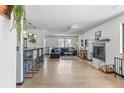 Spacious living room featuring hardwood floors, fireplace, bar seating, and natural light at 6680 E Mississippi Ave # 3, Denver, CO 80224