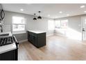 Kitchen boasts an island, sleek pendant lighting, stainless steel stove and an open, airy layout at 1568 Verbena St, Denver, CO 80220