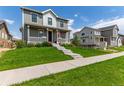 Beautiful home with a manicured lawn and inviting front porch at 9862 Reunion Pkwy, Commerce City, CO 80022