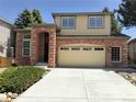 Charming two-story home featuring a brick facade, manicured lawn, and an attached two-car garage at 10538 Tiger Chase, Lone Tree, CO 80124