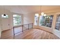 Bright living room featuring vaulted ceilings, large windows, wood floors, and modern chandelier at 10538 Tiger Chase, Lone Tree, CO 80124