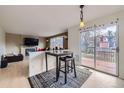 Open-concept dining area with bar-height seating, sliding glass doors to the deck, and seamless access to the living room at 19372 E 41St Ave, Denver, CO 80249