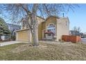 Charming tan two-story home with a two-car garage, brick accents, and cozy front porch swing at 19372 E 41St Ave, Denver, CO 80249