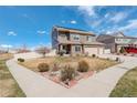 Well-manicured two-story home with solar panels, features an expansive front yard and a three car attached garage at 4971 Ceylon Way, Denver, CO 80249