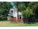 Charming two-story home with a fenced patio area, mature trees, and well-maintained landscaping at 8730 Chase Dr # 141, Arvada, CO 80003