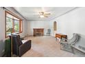 Spacious living room featuring a brick fireplace, ceiling fan, and natural light at 6050 Marshall Ct, Arvada, CO 80003