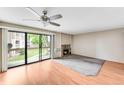 A spacious living room with hardwood floors, large windows, and a cozy fireplace at 4896 S Dudley St # 4-7, Littleton, CO 80123