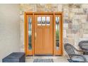 Elegant front door with sidelights and decorative glass on a stone facade at 17635 Silver Fox Ct, Mead, CO 80542