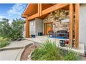 Inviting front porch with stone accents, a seating area, and well-manicured landscaping at 17635 Silver Fox Ct, Mead, CO 80542
