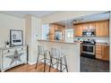 Kitchen with modern appliances, wood cabinets, and bar seating at 2280 W Center Ave, Denver, CO 80223