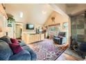 Cozy living room with vaulted ceilings, hardwood floors, fireplace, and comfortable seating area at 27389 Highway 74, Evergreen, CO 80439