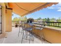 Balcony view of the landscaped property with a table, chairs, and shaded awning at 2500 E Cherry Creek South Dr # 306, Denver, CO 80209