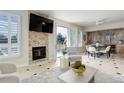 Bright living room featuring a stone fireplace, balcony access, and neutral decor at 2500 E Cherry Creek South Dr # 306, Denver, CO 80209