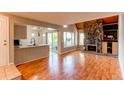 Open-concept living room with hardwood floors and a stone fireplace at 2479 S Xanadu Way # C, Aurora, CO 80014