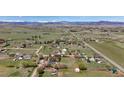 Expansive aerial view of a property showing a home, large yard, and surrounding landscape with mountain backdrop at 1720 Chaparro Cir, Berthoud, CO 80513