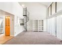Bright living room boasts soaring ceilings, large windows, and a unique spiral staircase at 14086 E Stanford Cir # F09, Aurora, CO 80015