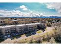 Exterior view of a modern apartment building with private balconies and mountain views at 6000 W Floyd Ave # 307, Denver, CO 80227