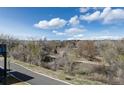 A lush landscape of tall trees provides privacy and beauty from this apartment balcony at 6000 W Floyd Ave # 307, Denver, CO 80227